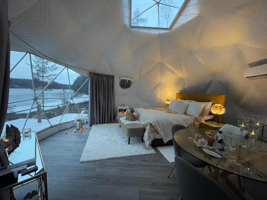 een grote slaapkamer met een bed en een groot raam bij Maja Luxury Glamping Suites in Mäntyharju