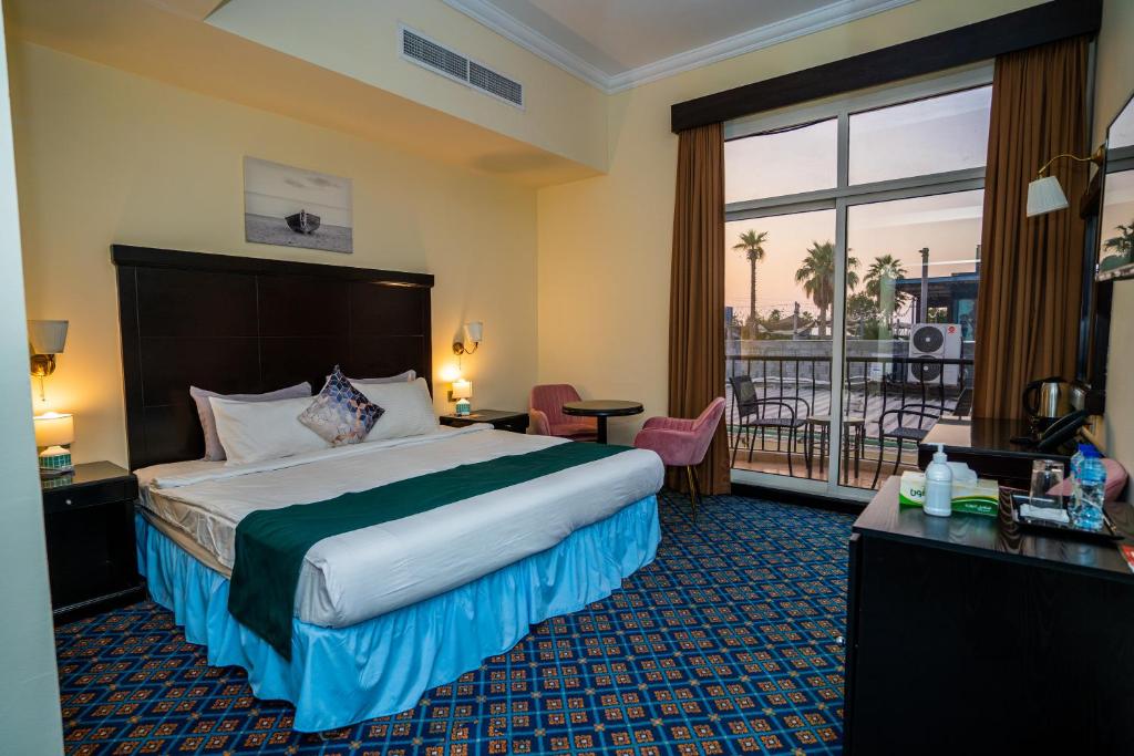 a hotel room with a bed and a balcony at Royal Prestige Hotel in Dubai