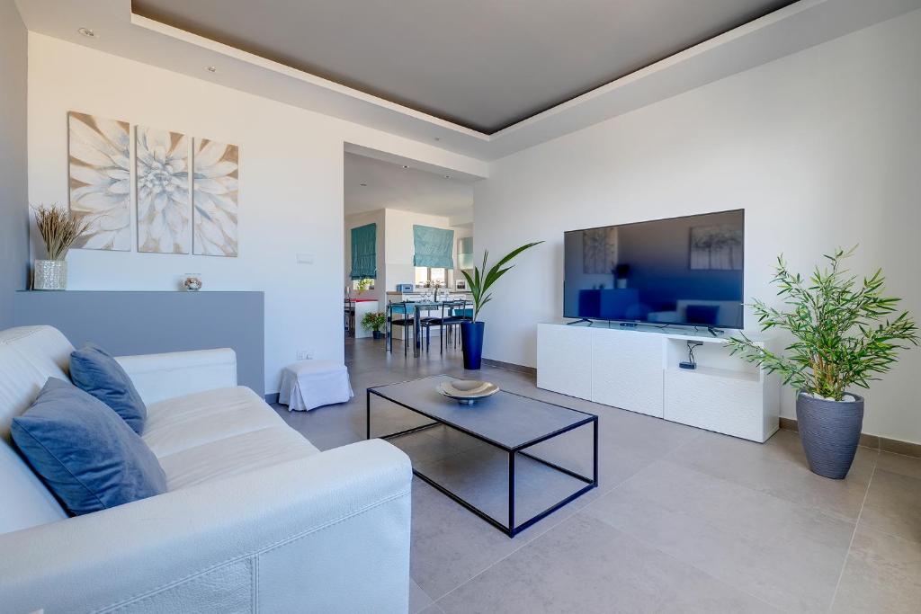 a living room with a white couch and a table at Perfect Location Idyllic 2BR Apartment in Sliema