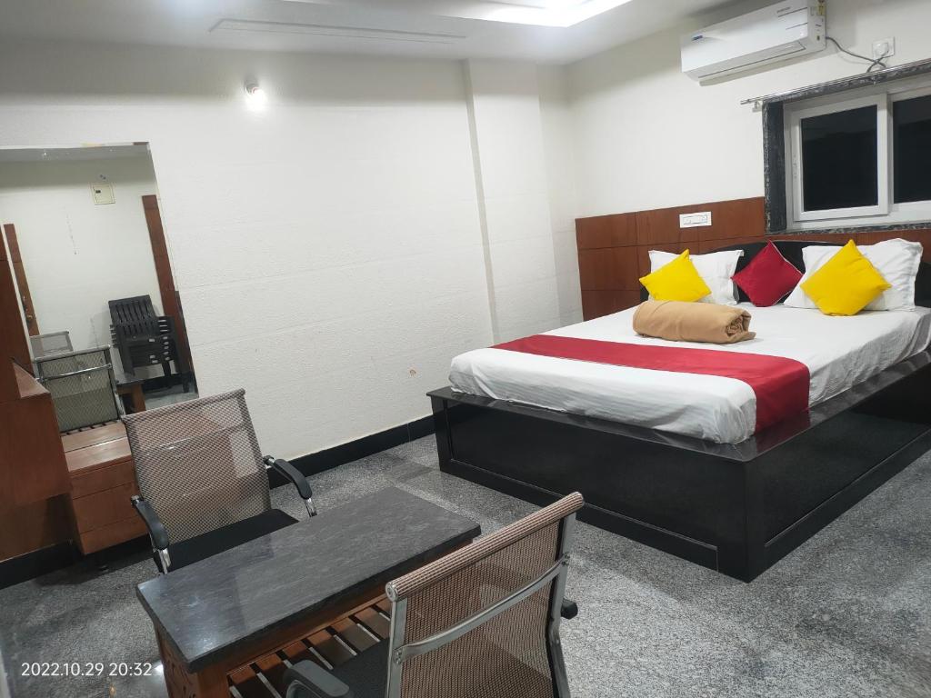 ハイデラバードにあるHotel New Maruthi Inn, LB Nagarのベッドルーム1室(黄色と赤の枕が付いたベッド1台付)
