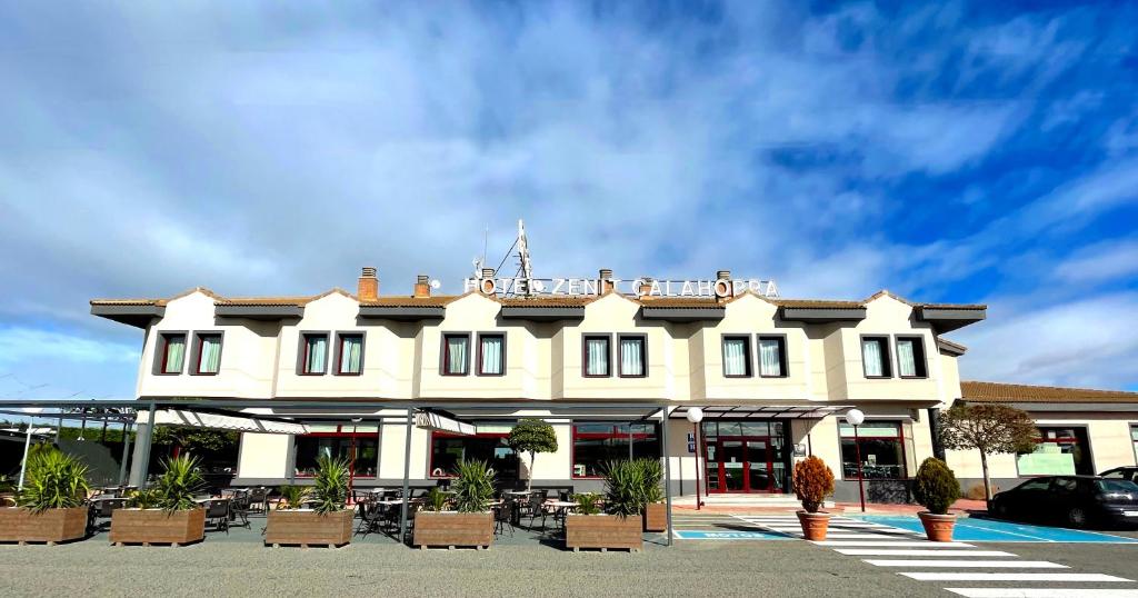 un gran edificio blanco con sillas en un aparcamiento en Nuevo Zenit Calahorra, en Calahorra