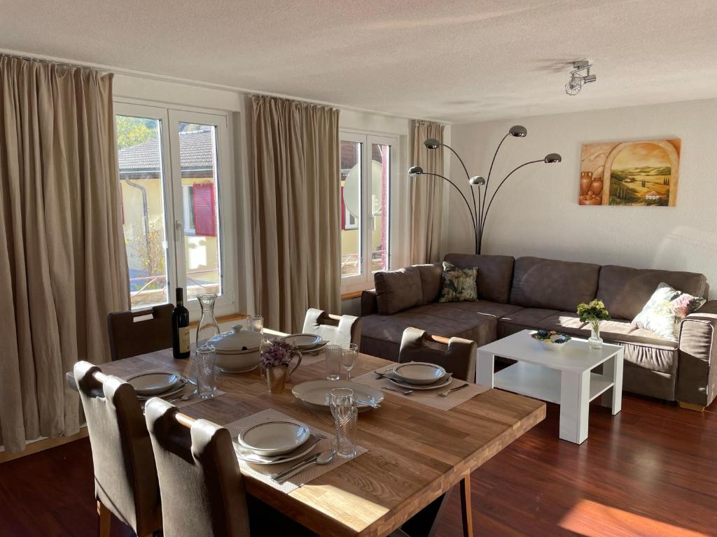 a living room with a table and a couch at Hubel Apartment 14 in Wilderswil