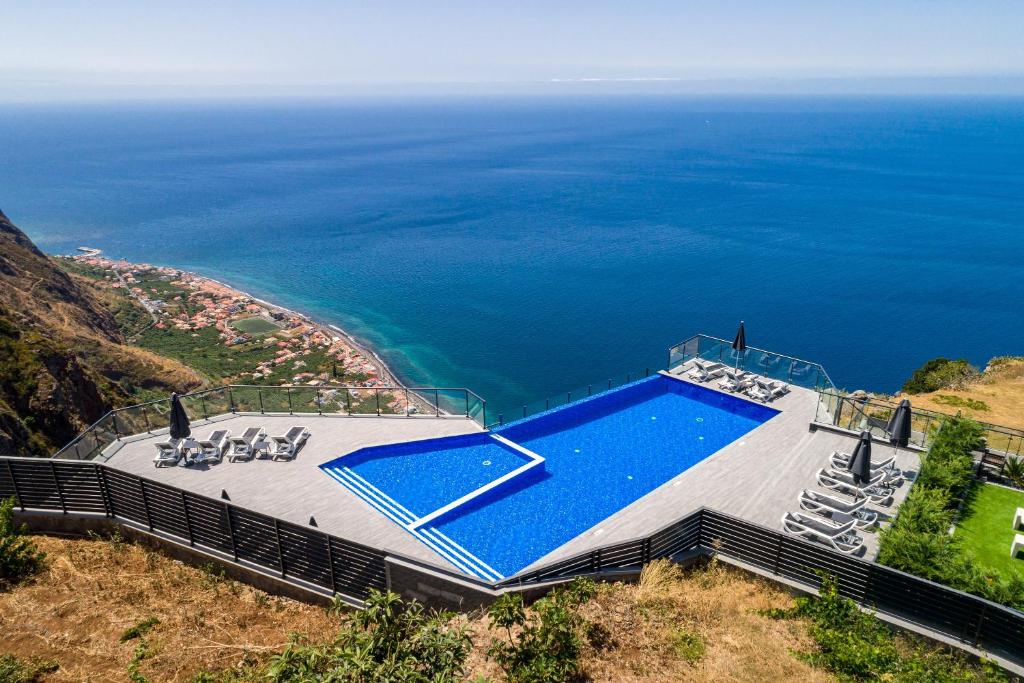 an aerial view of a swimming pool and the ocean at OurMadeira - Sunset Cliff Villas, contemporary in Fajã da Ovelha