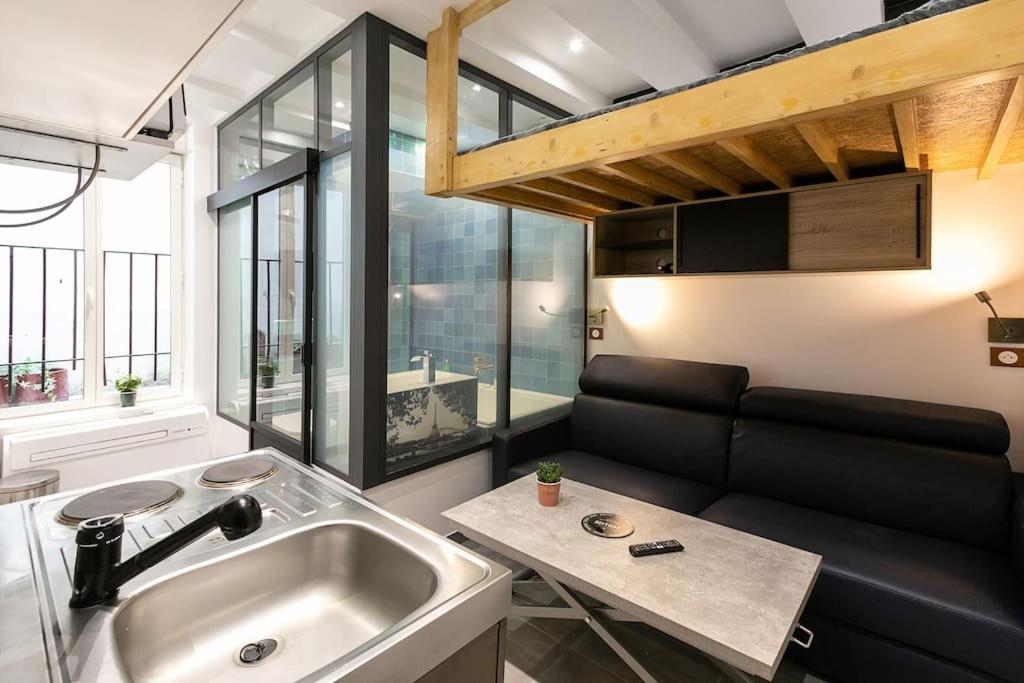 - un salon avec un lavabo et un canapé dans l'établissement Studio dans le 17ème, à 2km de Sacré Cœur, à Paris