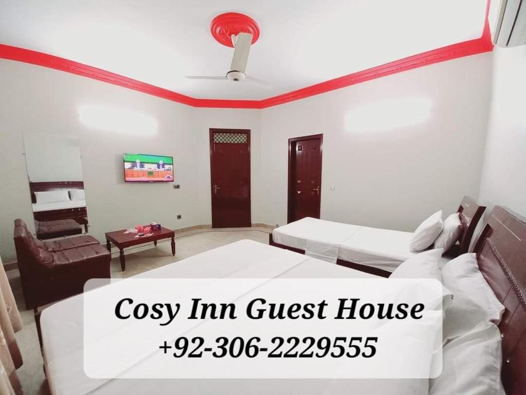 a room with a bed and a couch and a table at Cosy Inn Guest House Karachi in Karachi