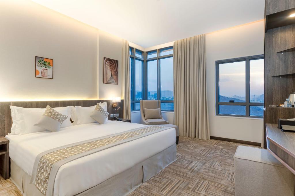 The Seasons Hotel في المدينة المنورة: غرفة فندقية بسرير كبير ونوافذ كبيرة