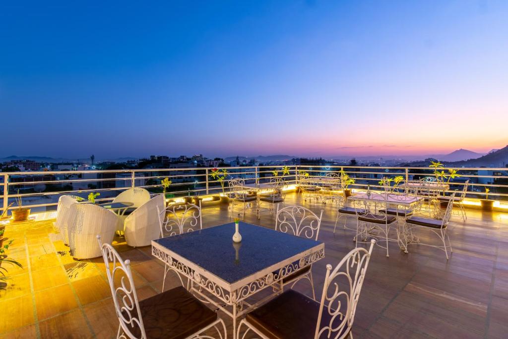 a patio with tables and chairs on a balcony at HOTEL THE CELEBRATION BY AMOD Best Hotel & Rooftop in Udaipur