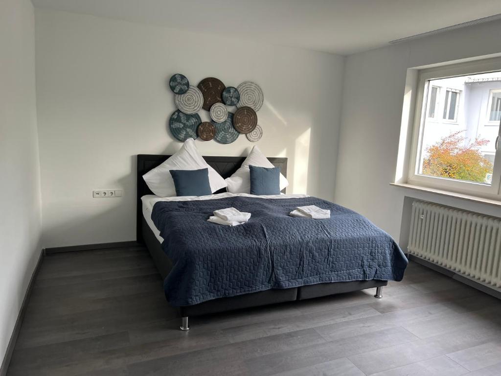 1 dormitorio con 1 cama con manta azul y ventana en Unique geräumige 4 Zimmer Wohnung in Tuttlingen mit Netflix, Sauna und Fitness en Tuttlingen