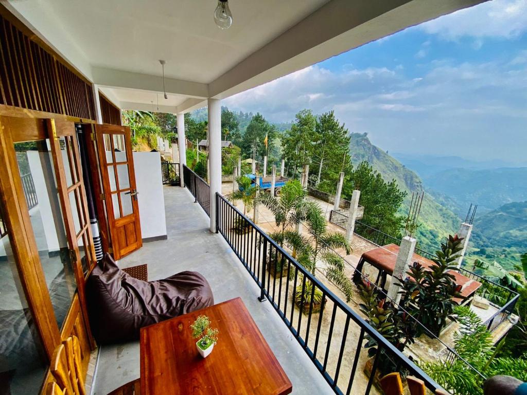 a balcony with a table and a view of the mountains at Misty peak view in Ella