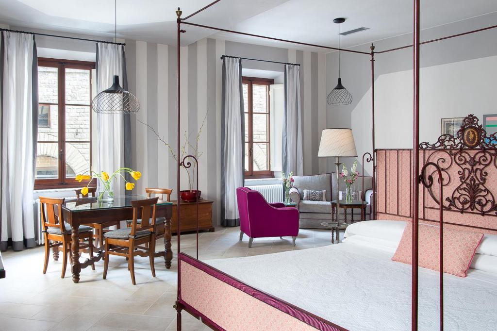 Un dormitorio con una cama y un comedor. en BorgoDeGreci Apartments, en Florencia