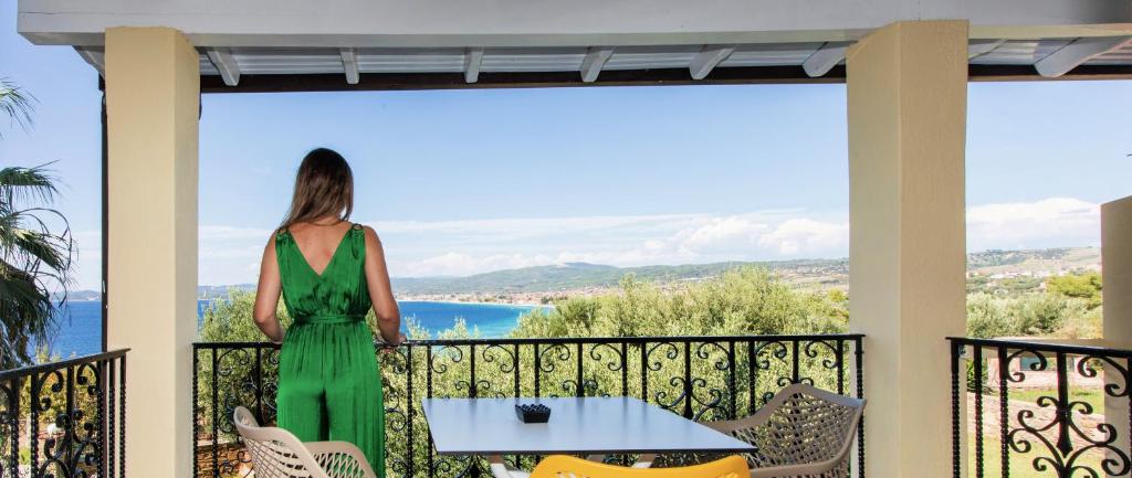 尼基季的住宿－Castristudios，站在一个眺望海洋的阳台上的女人