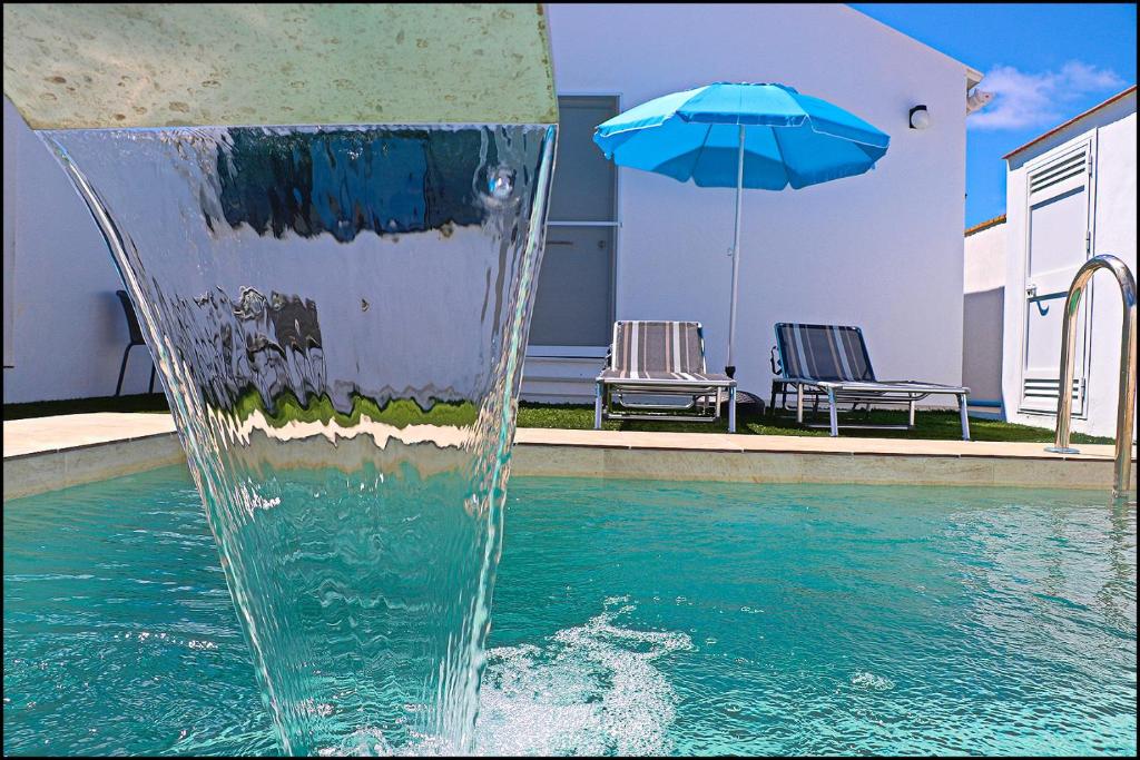una fontana d'acqua con un ombrellone in una piscina di Chalet los Morenos a Conil de la Frontera