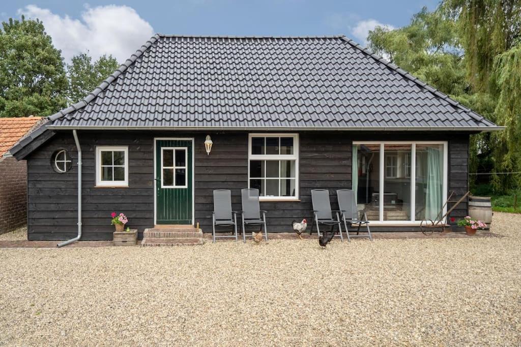 een klein huis met stoelen en een groene deur bij Vakantiehuisje aan de rand van Arnhem in Arnhem
