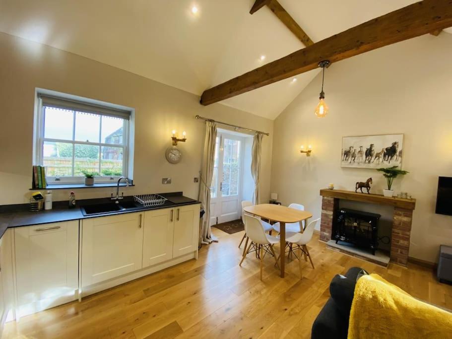 a kitchen and living room with a table and a dining room at The Stable - For A Unique Retreat in Hooe