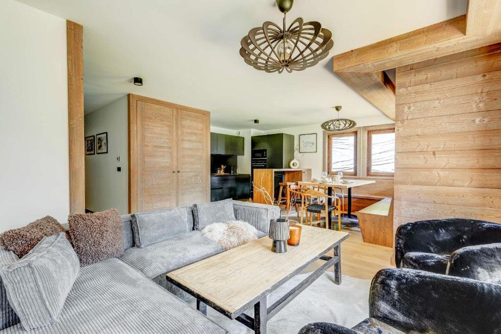 ein Wohnzimmer mit einem Sofa und einem Tisch in der Unterkunft Sublime appartement 3 chambres avec 200m2 jardin in Megève