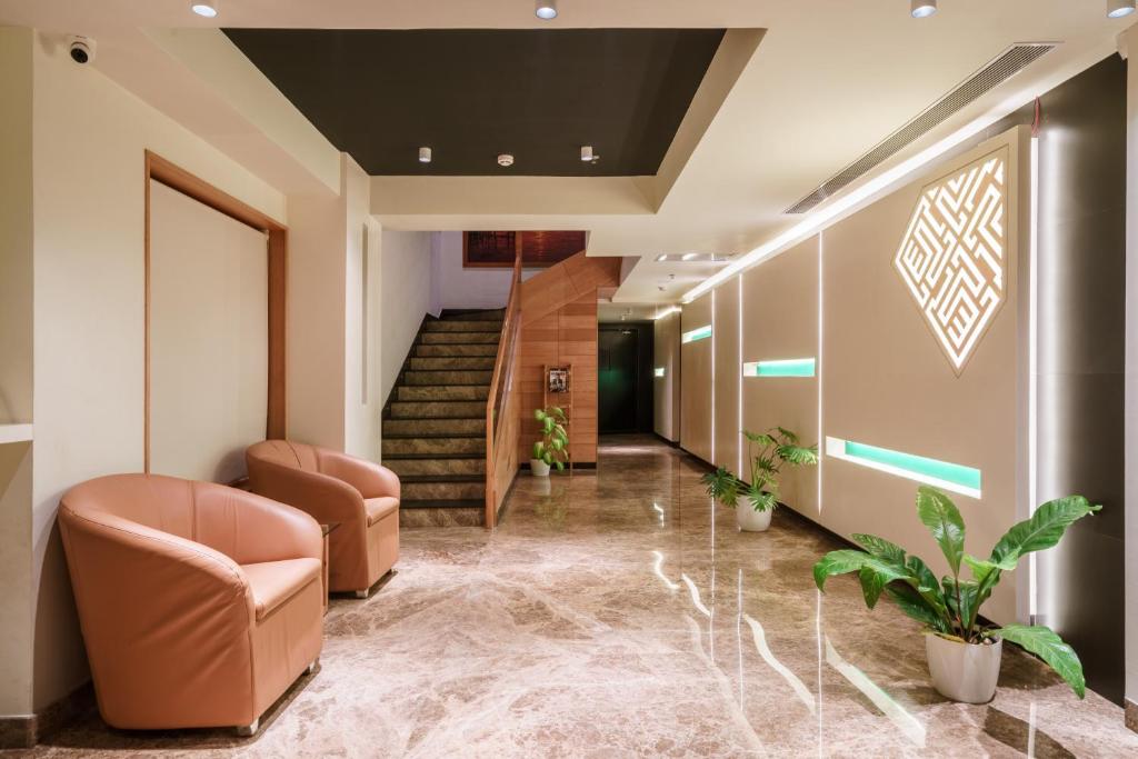 einen Flur mit Stühlen und Treppen in einem Gebäude in der Unterkunft Townbridge Hotels & Suites in Kochi