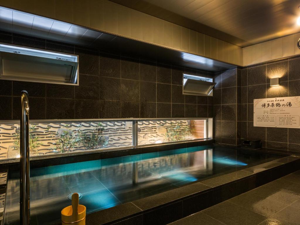 a swimming pool with blue lights in a building at Super Hotel Premier Hakataeki in Fukuoka