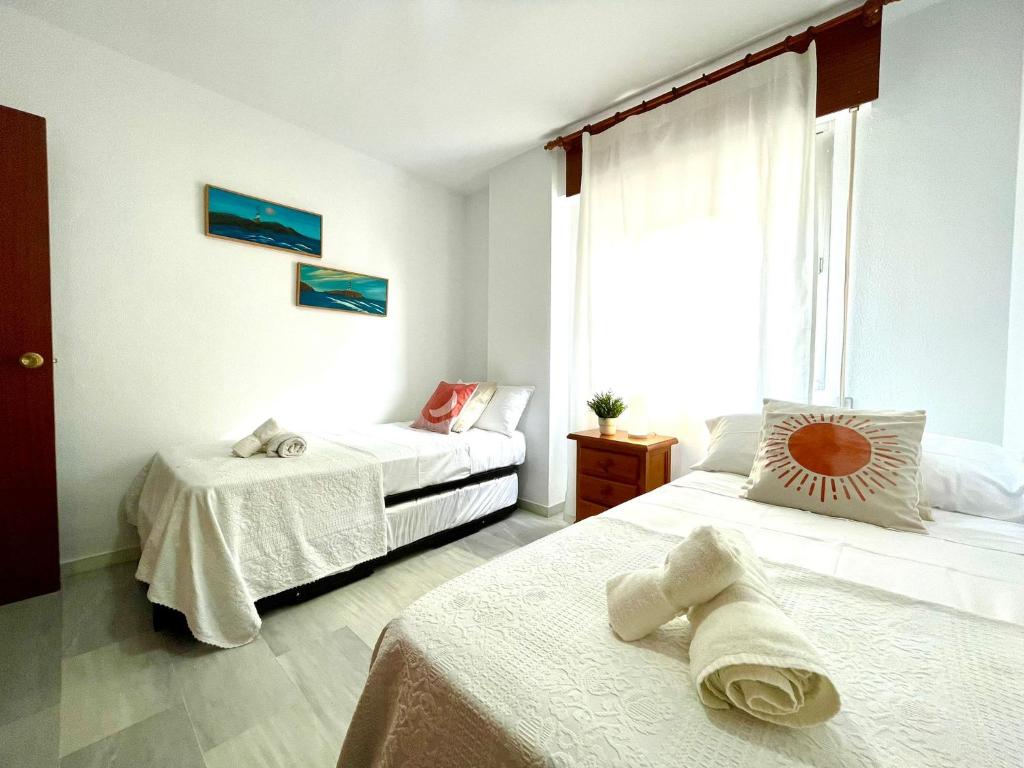 A bed or beds in a room at GATU Villa Sol, junto a la playa , piscina, 2 baños, aire cc, terraza, " Preferente mayores de 21 años y familias "