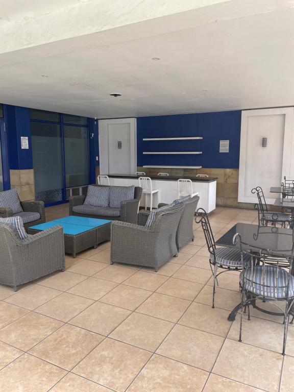 Habitación con sofás, mesas y cocina. en Oceanic View, en Durban