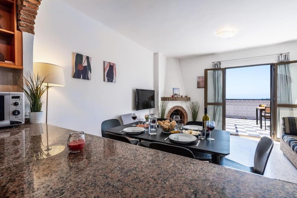 salon ze stołem i kominkiem w obiekcie Oasis 16 w mieście Nerja
