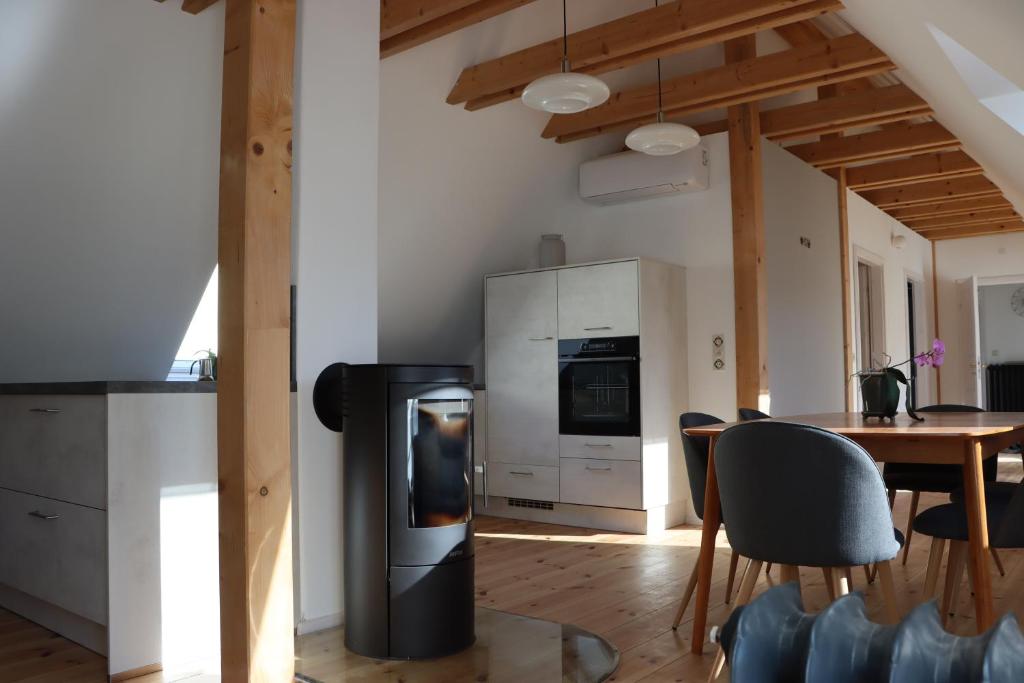 a kitchen and dining room with a stove and a table at Drei-Seiten-Hof Étable mit Schwimmteich und Klimanlage in Fuchshain