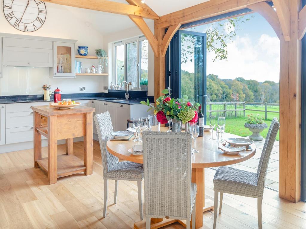 a kitchen and dining room with a table and chairs at Windover Barn in Slinfold