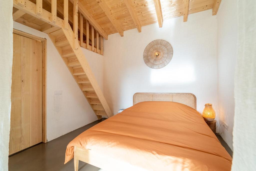 ein Schlafzimmer mit einem Bett in einem Zimmer mit einer Treppe in der Unterkunft Casa da Paz in Aljezur