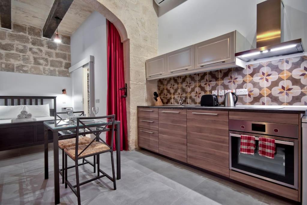 a kitchen with a table and a dining room at Vallettastay Old Lodge Studio 5 in Valletta
