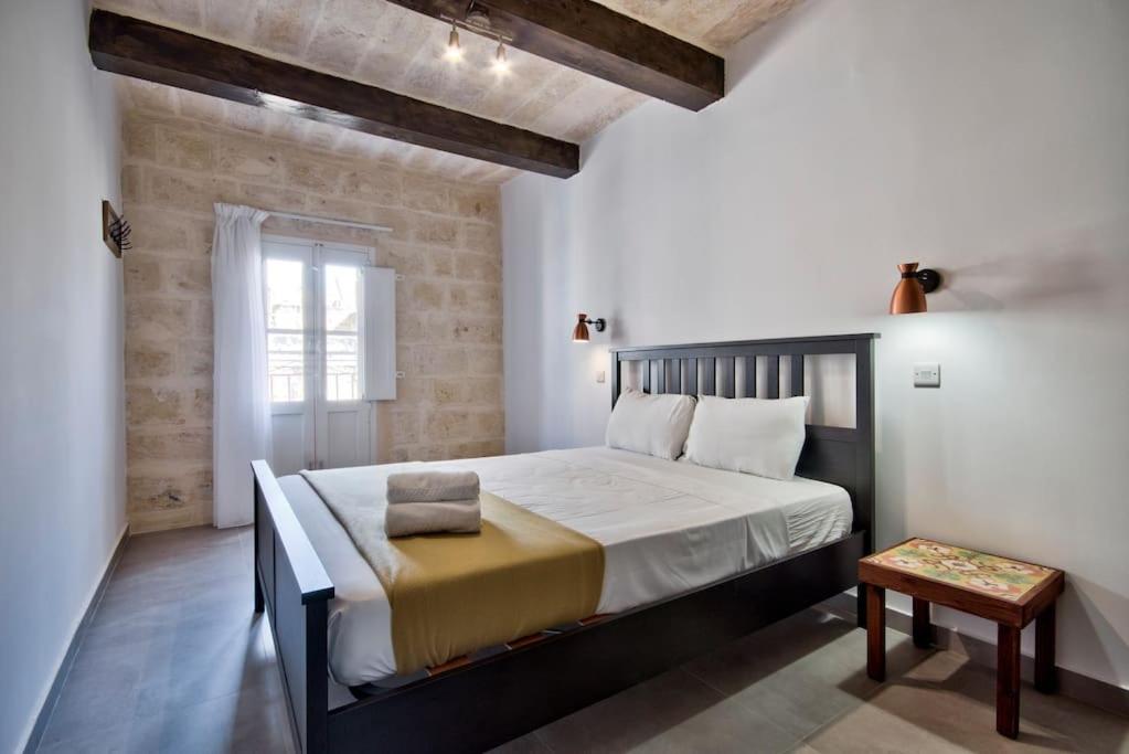 a bedroom with a large bed in a room at Vallettastay Old Lodge Apartment 7 in Valletta