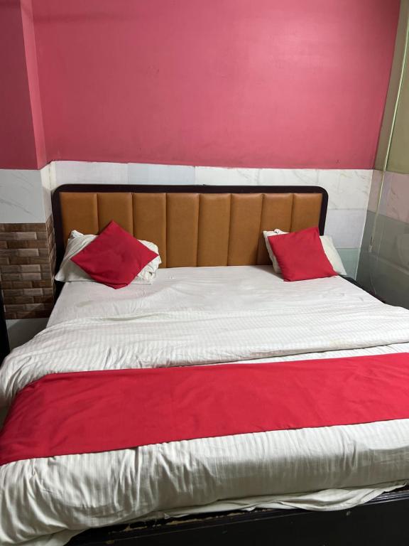 a bed with two red pillows on top of it at DKR REGENCY in Kurnool
