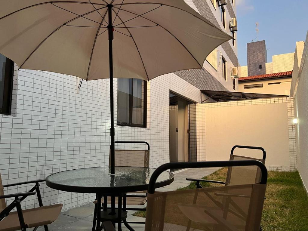 una mesa con sombrilla en el patio en Suas férias boa à Bessa, en João Pessoa