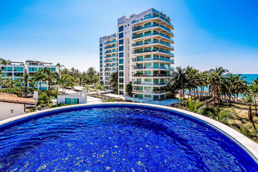 a large blue swimming pool in front of a tall building at Nitta 310 PH in Nuevo Vallarta 