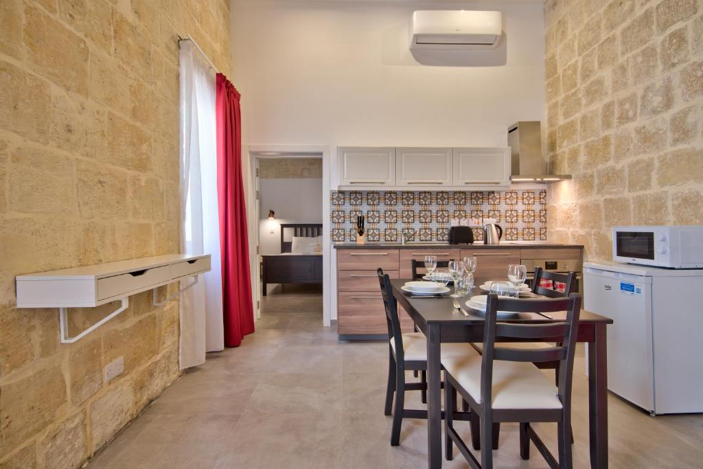 - une cuisine et une salle à manger avec une table et des chaises dans l'établissement Vallettastay Old Lodge Apartment 6, à La Valette