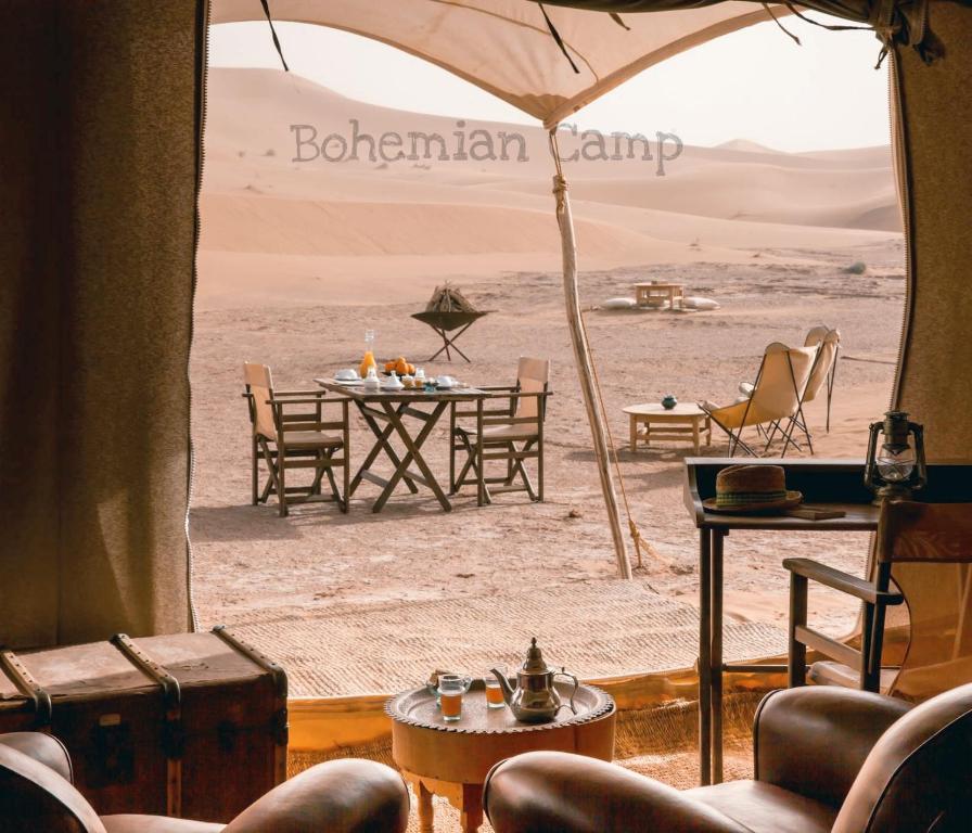 Habitación con mesa y sillas en el desierto en Bohemian Camp, en Merzouga