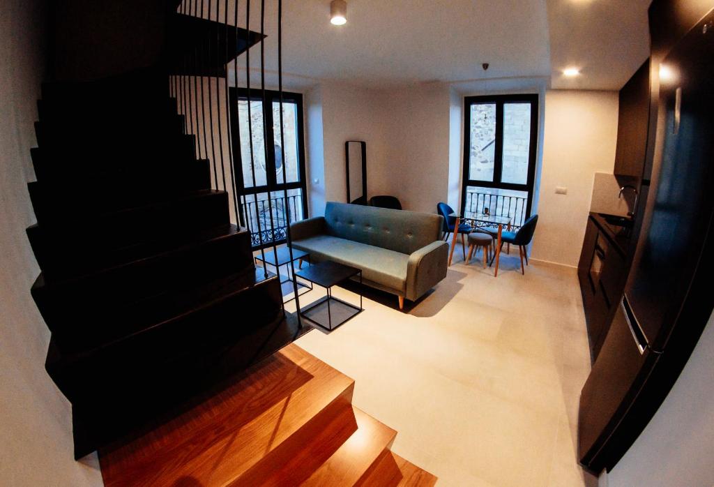 Ofrece vistas a una sala de estar con sofá y sillas. en Apartamentos Plaza de España 6, en Villanueva de la Serena
