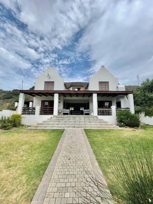 a large white house with a brick path in front of it at Living The Breede - Sanborg in Malgas