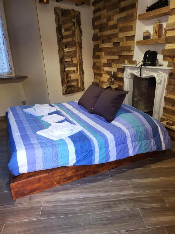 een bed met een blauw en wit dekbed en een open haard bij Ca de Sota in Luino