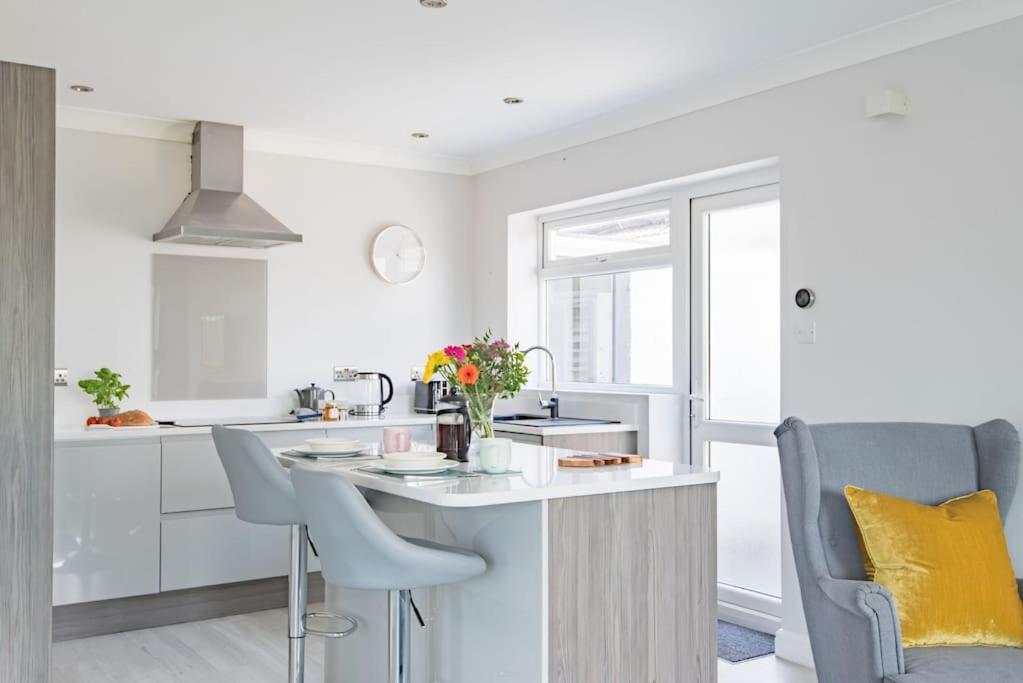 a kitchen with white cabinets and a table and chairs at The Heights in Kingsdown