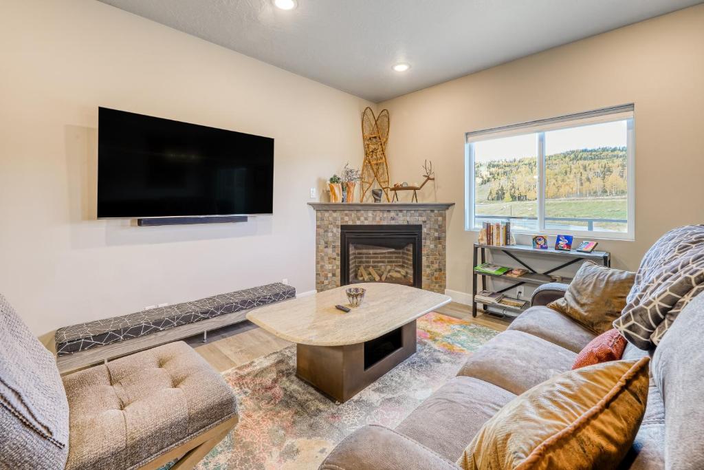 a living room with a fireplace and a flat screen tv at Crooked River #22 in Brian Head