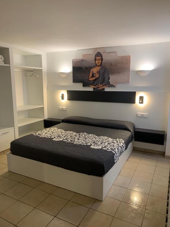 a bedroom with a bed with a picture on the wall at Pis Cala Tere in Cadaqués