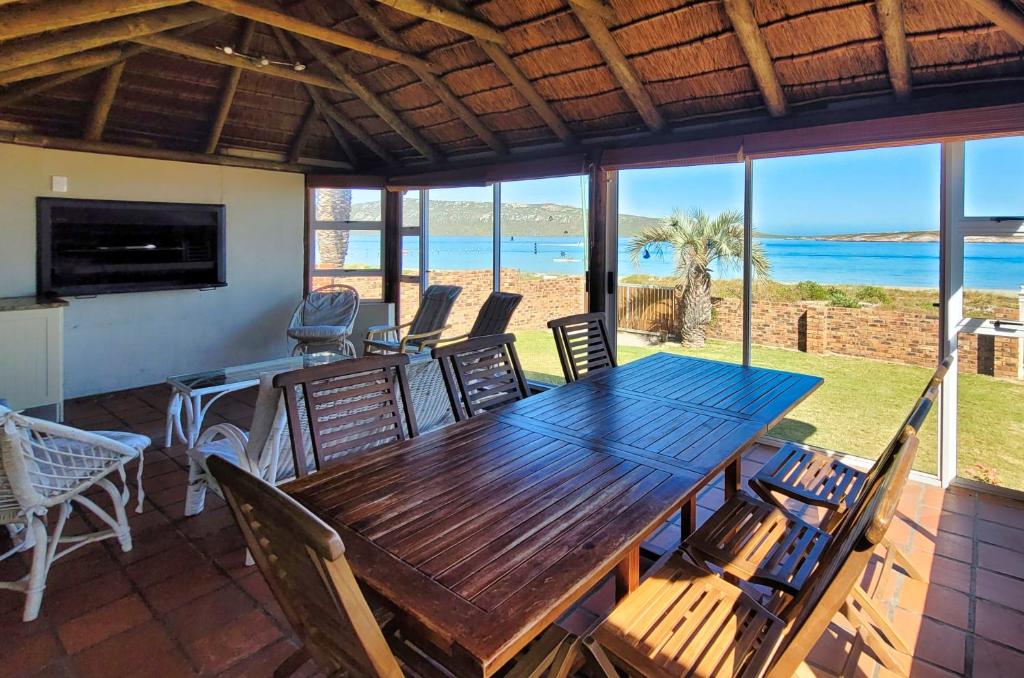 Un comedor con mesa y sillas de madera. en Seemansrust, Langebaan, 9-sleeper, en Langebaan