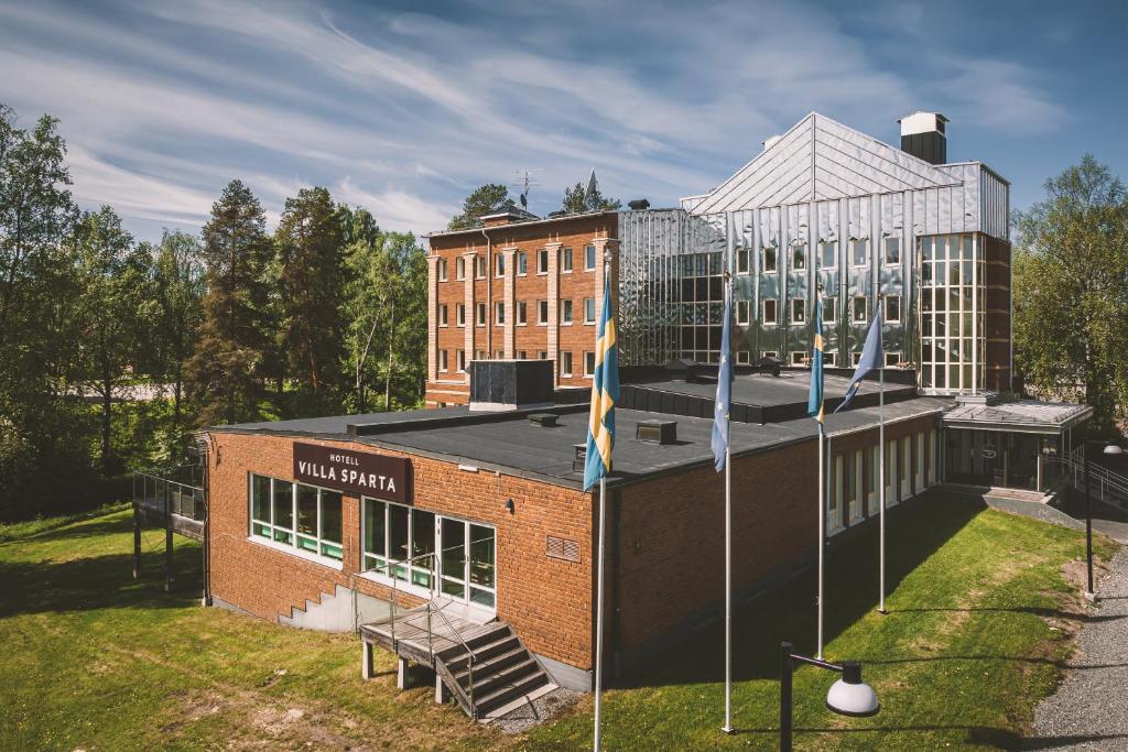 um edifício com duas bandeiras no telhado em Hotell Villa Sparta em Älvsbyn