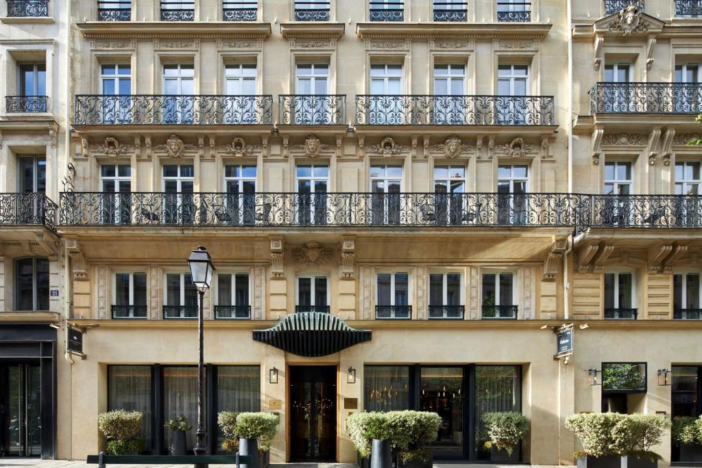 un bâtiment avec un balcon au-dessus dans l'établissement Maison Albar - Le Pont-Neuf, à Paris