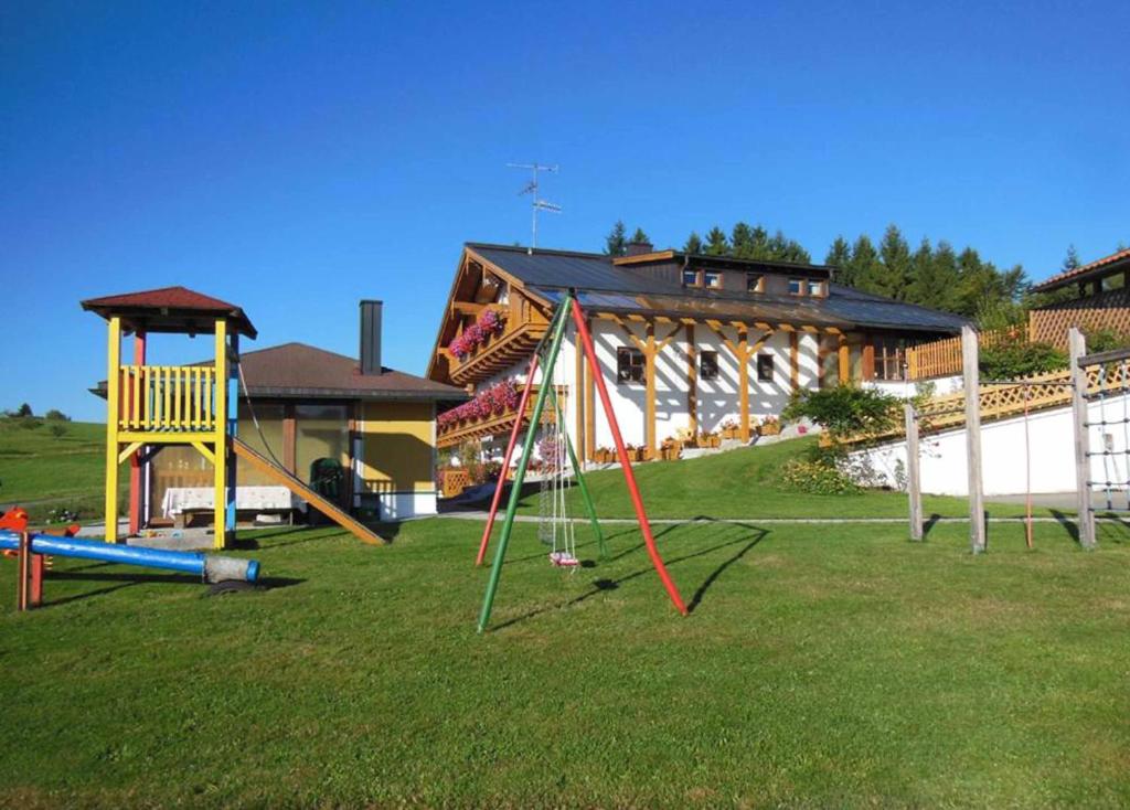 a group of playground equipment in a yard with a building at Haus Spannbauer-Pollmann in Neureichenau
