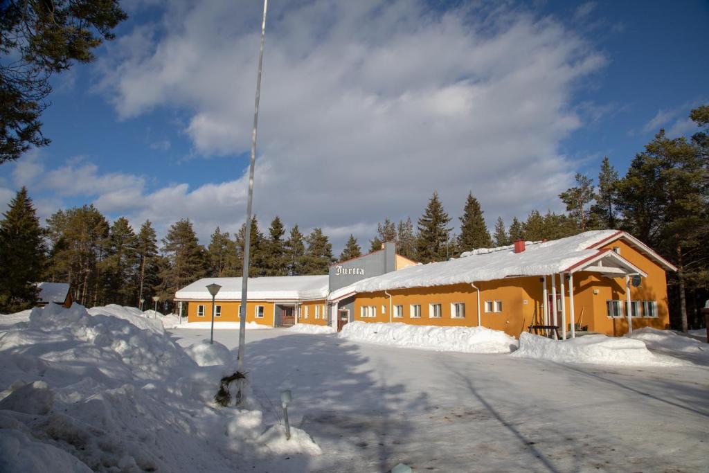 um grande edifício com neve em frente em Majatalo Jurtta em Rautuskylä