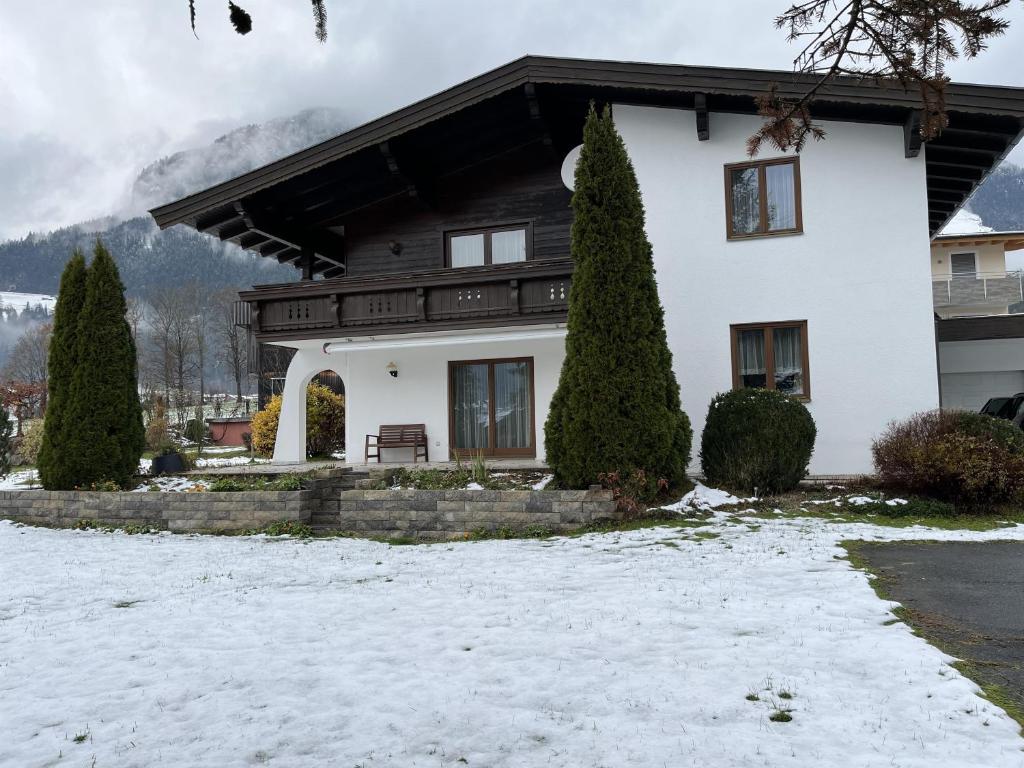 瑟爾的住宿－Ferienhaus Lanzinger，白房子,有树在雪中