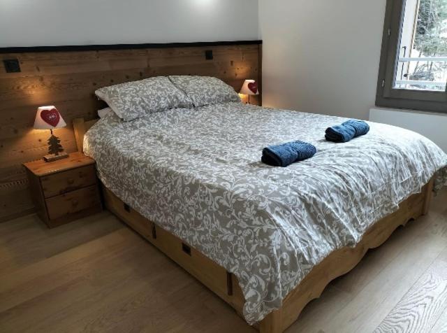um quarto com uma cama com duas almofadas azuis em White Pearl em Chamonix-Mont-Blanc