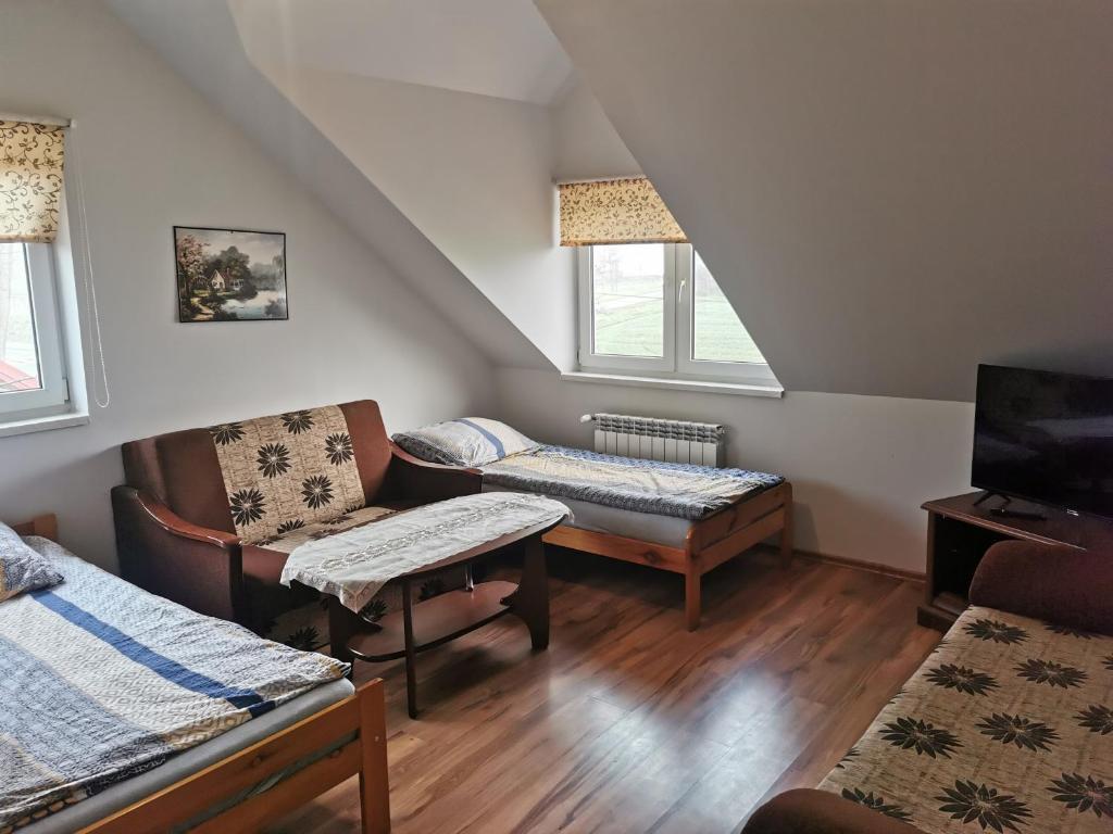 a attic room with a couch and a chair at Pokoje Gościnne Agnes in Sanok