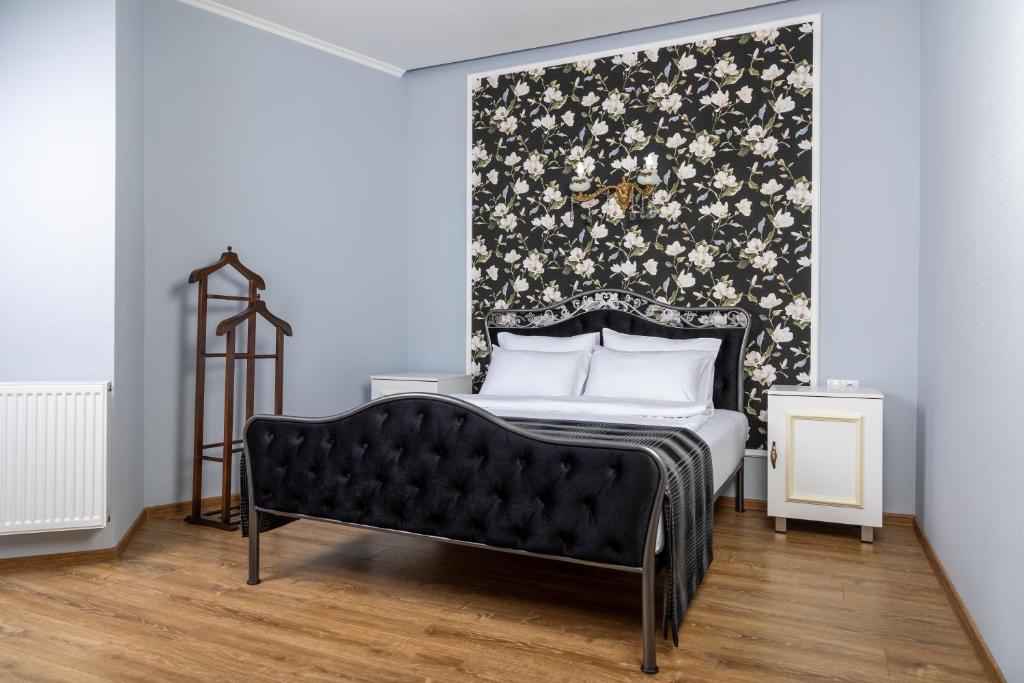 a bedroom with a bed and a black and white wall at Rose Hotel & Hostel Vake in Tbilisi City