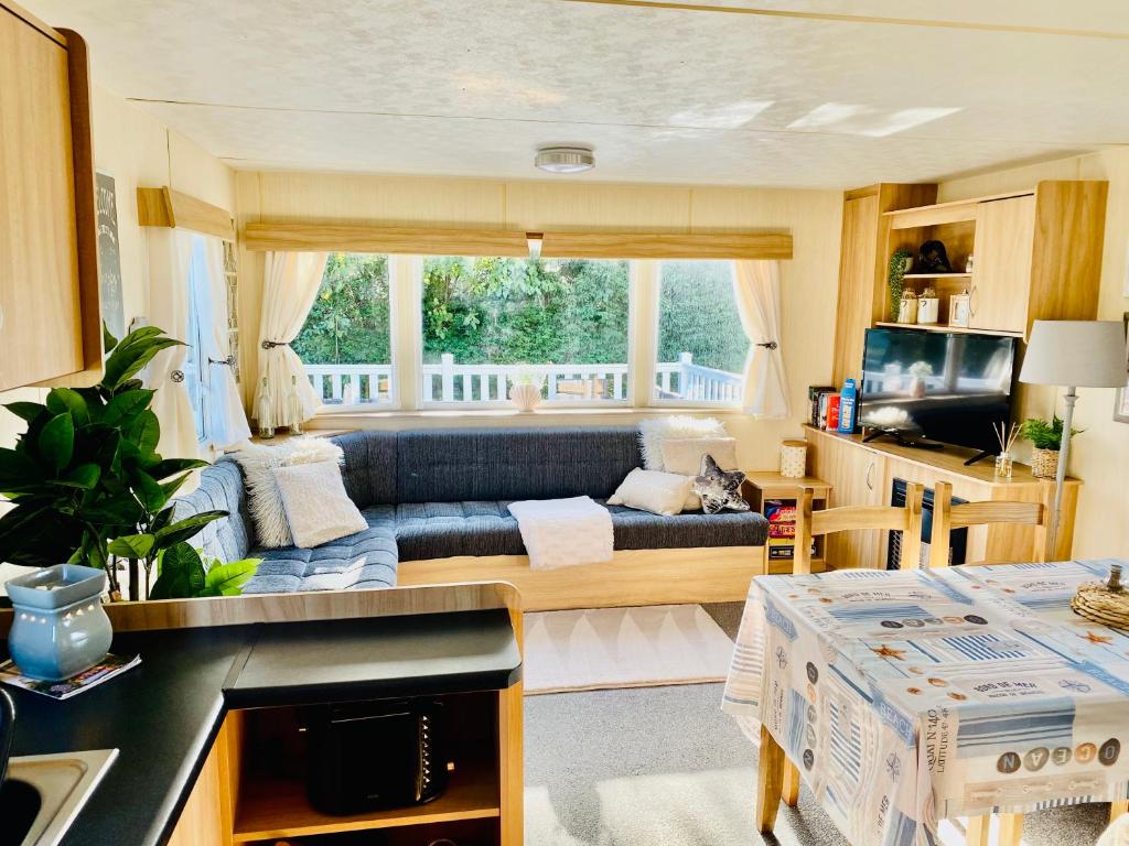 a living room with a couch in a caravan at Shell Beach Holiday Home Mersea Coopers Beach in East Mersea